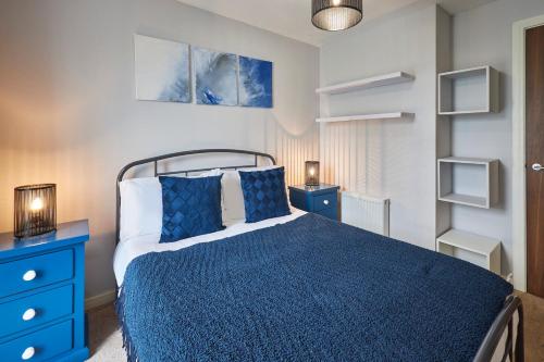 a bedroom with a blue bed and a blue dresser at Host & Stay - London Avenue in Glasgow