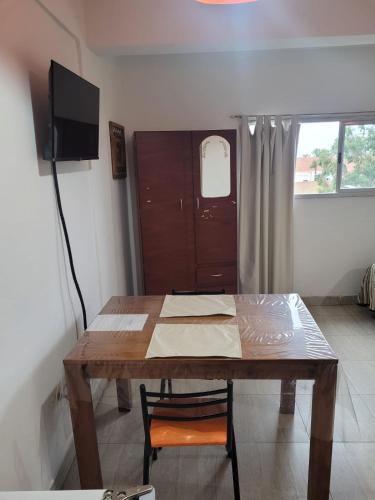 una mesa de madera y una TV en una habitación en SANBAN en Santiago del Estero