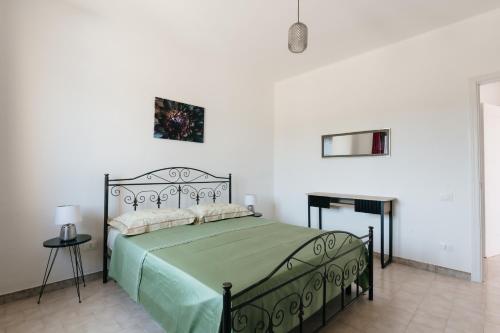 1 dormitorio con 1 cama con edredón verde en Villetta L'Ajara, en Ortelle