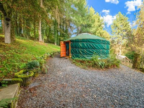 a green tent on a gravel road in a forest at Lively Holiday Home with Garden Barbecue Garden Furniture in Houffalize