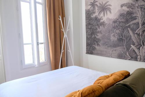 Un dormitorio con una cama con una ventana y una pintura en Villa Adèle, Sauna et Balcon vue Mer - Appt 03 en Mers-les-Bains