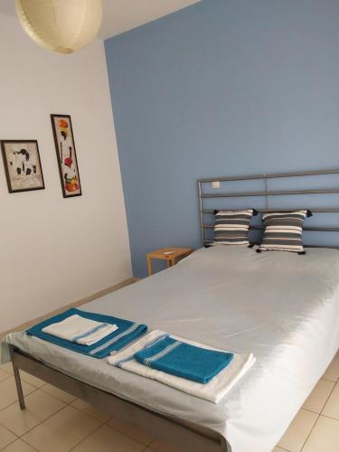 a bed with blue and white sheets and pillows at Amor de Skioni in Nea Skioni