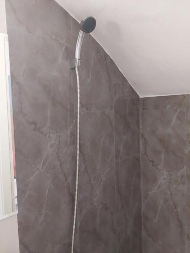 a shower head in a bathroom with a stone wall at Amor de Skioni in Nea Skioni