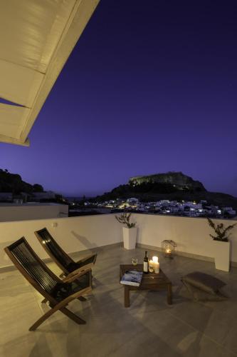 a room with a chair and a table at night at Lindian Pearl in Líndos