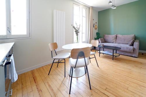 a living room with a table and chairs and a couch at Villa Adèle, Sauna et Balcon vue Mer - Appt 03 in Mers-les-Bains