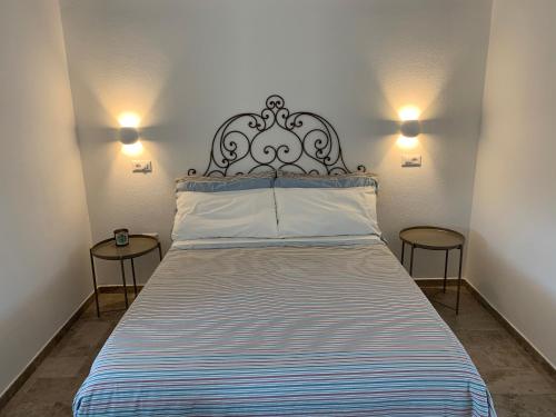 a bedroom with a large bed with two tables at Stazzu nuraghe Mannucciu in Rena Majore