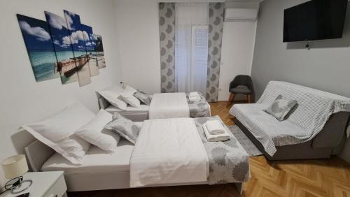 a room with a bed and a television in it at Apartman Magnolija in Rijeka