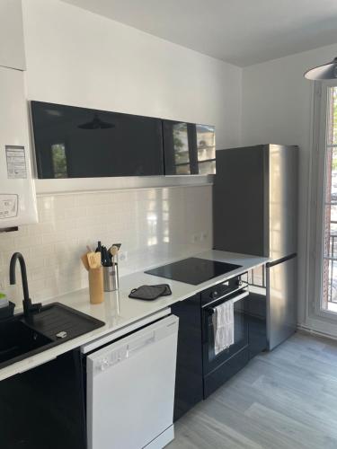 a kitchen with black and white counters and appliances at Vivez au coeur Historique - St François - Grand appartement confortable in Le Havre