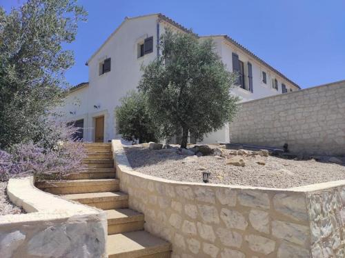 une maison avec un mur en pierre et des escaliers devant dans l'établissement Magnifique Mas contemporain, à Fontvieille