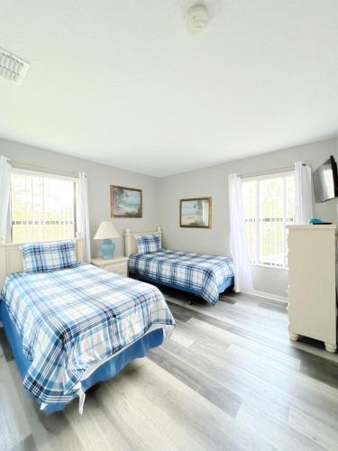 a bedroom with two beds and two windows at Gone 2 Florida Vacation Homes in Orlando