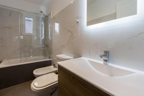 La salle de bains est pourvue d'un lavabo, de toilettes et d'une douche. dans l'établissement Duplex Bahía Grande, à Ushuaia