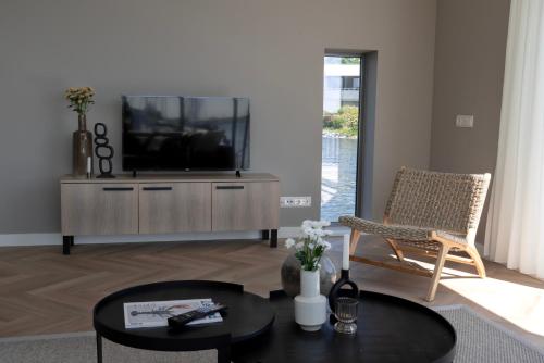 a living room with a television and a chair at Villa Nautica Kortgene in Kortgene