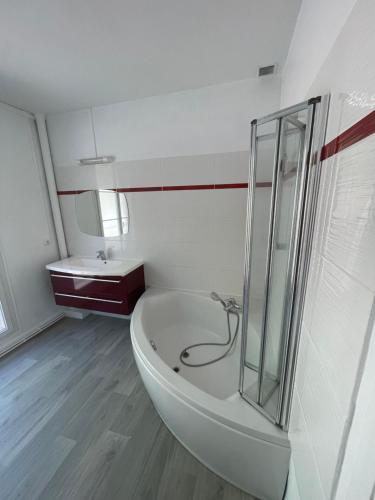 La salle de bains blanche est pourvue d'une baignoire et d'un lavabo. dans l'établissement Vivez au coeur Historique - St François - Grand appartement confortable, au Havre