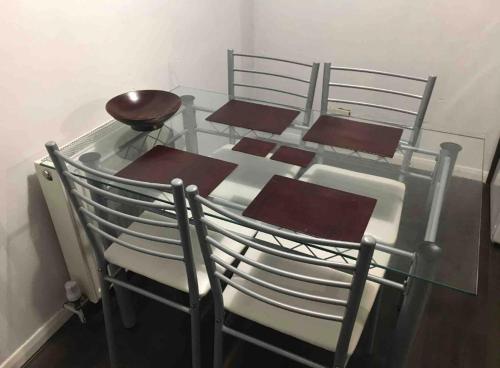 un groupe de chaises assises autour d'une table en verre dans l'établissement Eastbourne Twin room, à Polegate