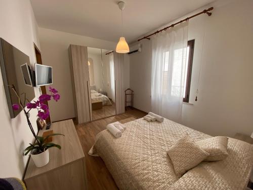 una camera da letto con un letto e asciugamani di CASA NO-MA in centro storico a Marsala