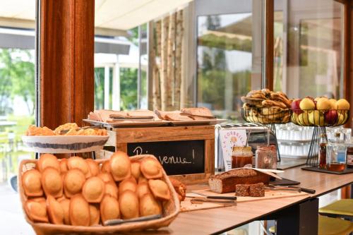 a table with bread and pastries on it at Novotel Paris Créteil Le Lac in Créteil