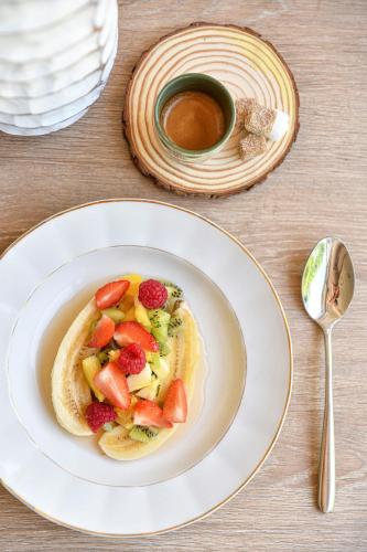 a plate of food with fruit and a cup of coffee at Novotel Paris Créteil Le Lac in Créteil