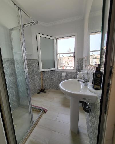 ein Bad mit einem Waschbecken und einer Dusche in der Unterkunft Résidence De Luxe AL Manzah in Al Hoceïma