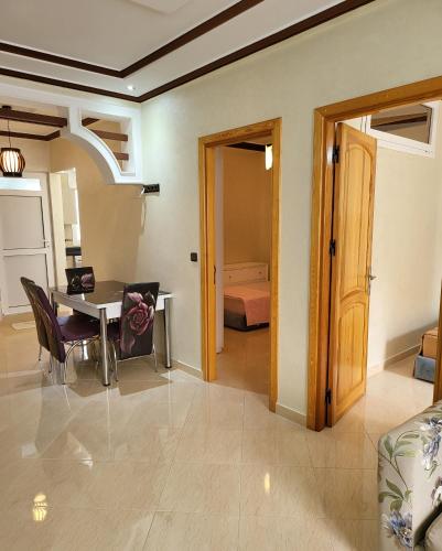 a living room with a table and a bedroom at Résidence De Luxe AL Manzah in Al Hoceïma