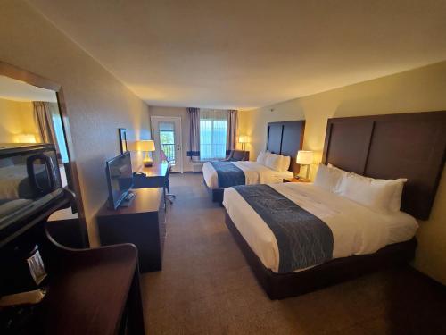 Comfort Inn & Suites Munising-Lakefront في مونيسينغ: غرفة فندقية بسريرين وتلفزيون بشاشة مسطحة