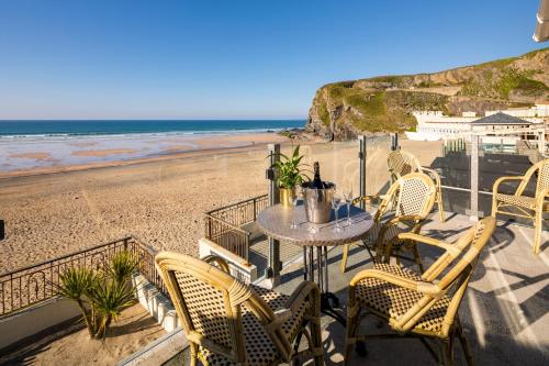 a patio with a table and chairs on the beach at Tolcarne Beach Apartments in Newquay