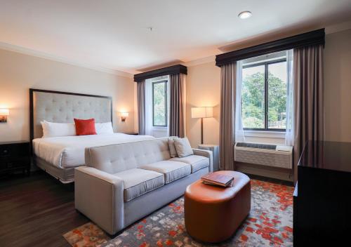 a bedroom with a white bed and a couch at The Abernathy in Clemson