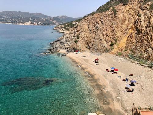 a beach with people laying on the sand and the water at orizzonte mare in Teulada