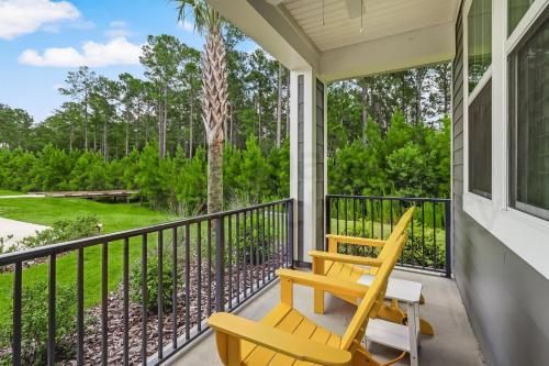 a porch with a yellow bench and a tree at 632 Palmetto Place - Wildlight home in Yulee