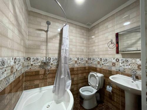 a bathroom with a tub and a toilet and a sink at Anor Qal'a in Khiva