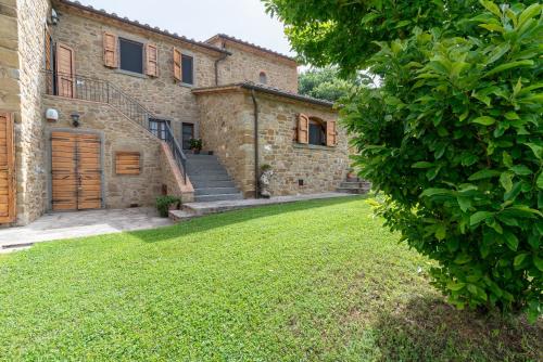 an external view of a house with a grass yard at Villa in esclusiva - Pugnano Alto in Lisciano Niccone