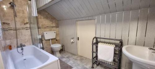 a bathroom with a sink and a tub and a toilet at Sleeps 20 Stunning Ashton Mansion in Ashton under Lyne