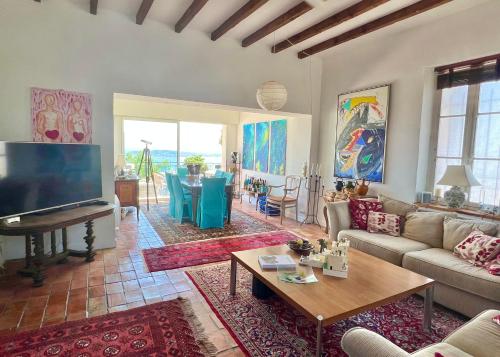 a living room with a couch and a tv and a table at Castel Horizon - Super Cannes - 360 Degrees View in Vallauris
