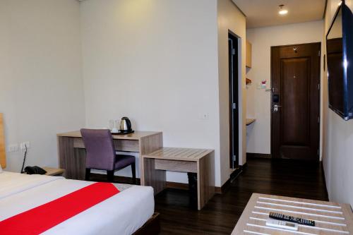 Habitación de hotel con cama y escritorio en Airo Hotel Manila en Manila