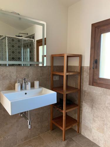 雷納馬約勒的住宿－Stazzu nuraghe Mannucciu，浴室设有白色水槽和镜子