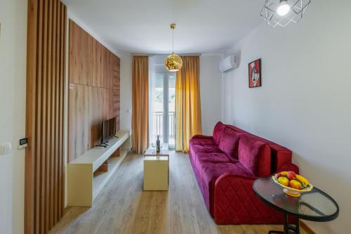 a living room with a red couch and a table at Pini Apart-hotel in Kolašin