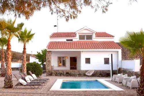una villa con piscina di fronte a una casa di Venta Viñas, finca privada en la naturaleza, con piscina a Mejorada