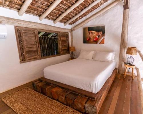 a bedroom with a bed made out of logs at Villa Fulô in Caraíva