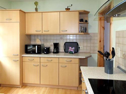 a kitchen with wooden cabinets and a counter top at Pension Grenzeck in Bad Schandau