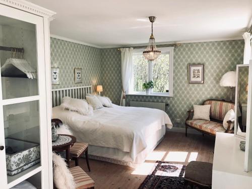 een slaapkamer met een bed, een bank en een raam bij Engsholms Slott - Adults Only in Mörkö