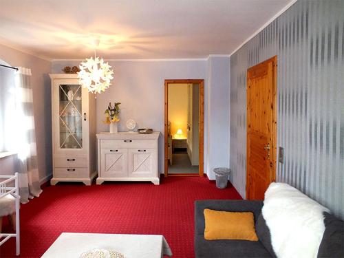 a living room with a couch and a chandelier at Pension Grenzeck in Bad Schandau