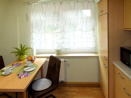 a dining room table with two chairs and a window at Pension Grenzeck in Bad Schandau