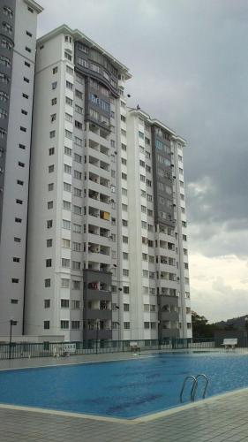 a large building with a swimming pool in front of it at Budget Single Bedroom at Suria Kipark Damansara with foldable mattress for 2 pax in Kuala Lumpur