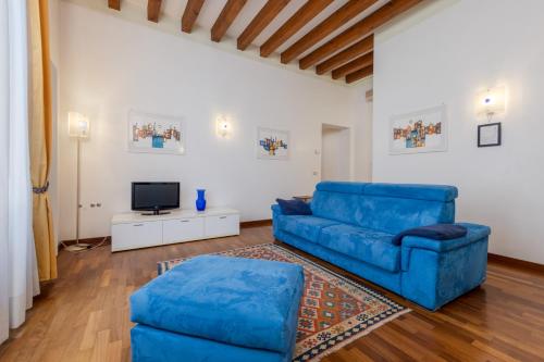 a living room with a blue couch and a tv at Corte Nova in Venice