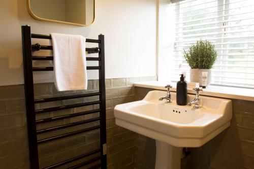 a bathroom with a sink and a mirror and a window at Alvanley Arms, Cotebrook in Tarporley