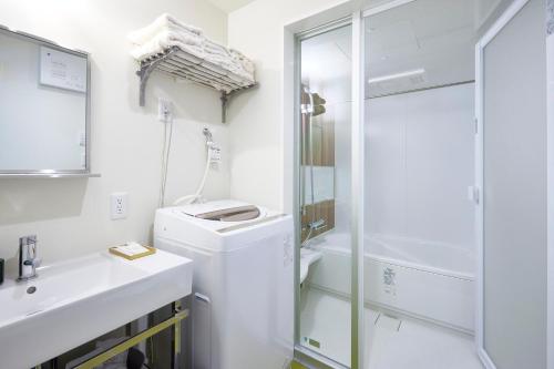 COFFEE HOTEL Soundwave في فوجيساوا: حمام أبيض مع حوض ودش