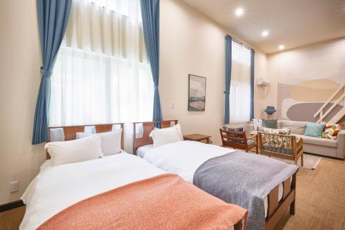 藤沢市にあるCOFFEE HOTEL Soundwaveのベッドルーム1室(ベッド2台付)、リビングルームが備わります。