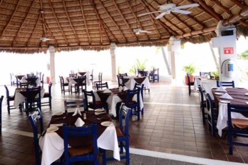 comedor con mesas y sillas y techo en Departamento junto a las hadas manzanillo en Manzanillo