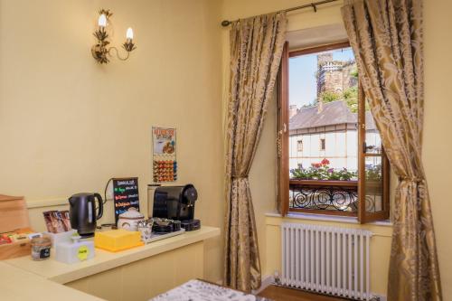 Cette chambre dispose d'une fenêtre offrant une vue sur un bâtiment. dans l'établissement La Ruche Chambres d'hôtes, à Ségur-le-Château