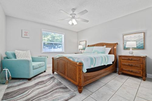 ein Schlafzimmer mit einem Bett und einem blauen Stuhl in der Unterkunft Beachy 2-1 Condo in Palm Harbor