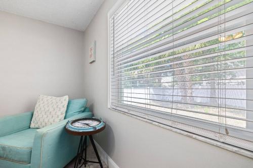 a room with a blue couch and a window with blinds at Beachy 2-1 Condo in Palm Harbor